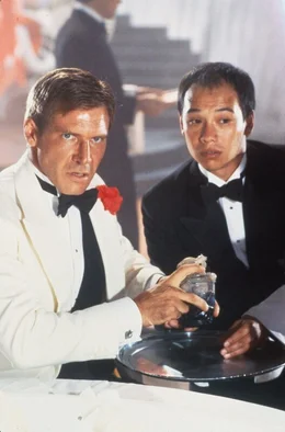 Indiana Jones (Harrison Ford, l.) wagt sich zusammen mit Wu Han (David Yip, r.) in die H&ouml;hle des L&ouml;wen. Indy sollte f&uuml;r den brutalen und hinterh&auml;ltigen Gangsterboss Lao Che ein wertvolles Artefakt besorgen, doch Lao will Indy bei dem Deal &uuml;bers Ohr hauen ...