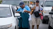 Straßenhandel am Grenzübergang: Zwei Männer nutzen den Stau, um Autofahrern Kleidung anzubieten. Straßenhandel am Grenzübergang: Zwei Männer nutzen den Stau, um Autofahrern Kleidung anzubieten.