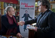 Der L&uuml;becker Autor des Bestsellers "Dirigent der Liebe" Didier Moretti (Michael Lott, l.) begr&uuml;&szlig;t den Drucker Malte Henning (Ulrich B&auml;hnk, r.).