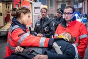 Während Dr. Eva Grünberg (Laura Berlin, l.) sich um das Opfer eines brutalen Überfalls kümmert, treffen Mattes (Matthias Schloo, 2.v.l.) und Melanie (Sanna Englund, 2.v.r.) am Einsatzort ein. Während Dr. Eva Grünberg (Laura Berlin, l.) sich um das Opfer eines brutalen Überfalls kümmert, treffen Mattes (Matthias Schloo, 2.v.l.) und Melanie (Sanna Englund, 2.v.r.) am Einsatzort ein.