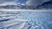 Katabatische Winde treiben Schnee &uuml;ber die Oberfl&auml;che des Lake Untersee in der Ost-Antarktis, an dessen Grund riesige Stromatolithen liegen, die nirgendwo sonst auf der Erde zu finden sind.