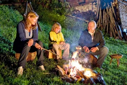 Susanne (Birge Schade, li.), Markus (Jan-Gregor Kremp) und der kleine Ludwig (Sandro Iannotta) machen es sich am Lagerfeuer gem&uuml;tlich.