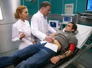 David Bohm (Peter Sikorski, re.) hat einen Leistenbruch verschwiegen, um sich um seine querschnittsgel&auml;hmte Freundin zu k&uuml;mmern. Oberschwester Ingrid (Jutta Kammann, li.) hat darauf bestanden, dass er sich untersuchen l&auml;sst. Dr. Roland Heilmann (Thomas R&uuml;hmann, Mitte) macht David klar, dass er sich damit in eine lebensgef&auml;hrliche Situation gebracht hat und jetzt notoperiert werden muss.