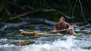 Hazen rudert auf einem selbstgebauten Flo&szlig; in kabbeligem Wasser.