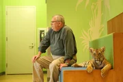 Jim Breheny sits next to tiger cub.