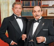 "Agatha Christie's Poirot", "Nikotin." Sir Charles Cartwright, ein bekannter Schauspieler und Freund von Poirot, l&auml;dt zur Abendveranstaltung ein. Noch w&auml;hrend der Begr&uuml;&szlig;ung bricht Pfarrer Babbington tot zusammen, nachdem er einen Schluck von einem Drink genommen hat. Zun&auml;chst sieht es nach einem nat&uuml;rlichen Tod aus. Doch einen Monat sp&auml;ter l&auml;dt einer der G&auml;ste namens Sir Bartholomew Strange seinerseits ebenfalls zum Dinner und stirbt unter verbl&uuml;ffend &auml;hnlichen Umst&auml;nden. Zuvor jedoch hatte er angek&uuml;ndigt etwas erfahren zu haben. Nun stellt sich heraus, dass Sir Bartholomew mit Nikotin vergiftet wurde, einer farb- und geruchlosen Fl&uuml;ssigkeit, das wegen seiner Eigenschaften als starkes Nervengift normalerweise zum Bespr&uuml;hen von Rosen eingesetzt wird. Gemeinsam mit Cartwright und der jungen Lytton Gore, genannt "Egg", beginnt Poirot zu ermitteln. Poirot inszeniert nun einen dritten Abendempfang, um seine Verdachtsmomente erh&auml;rtet zu sehen. Im Bild (v.li.): Martin Shaw (Sir Charles Cartwright), David Suchet (Hercule Poirot).