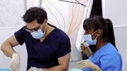 Dermatologist (Adil Sheraz,r.) treating a patient in operation theater