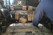 Ein CBP-Beamter holt am Grenz&uuml;bergang in Hidalgo, Texas, mehrere Pakete mit mutma&szlig;lichen Bet&auml;ubungsmitteln aus einem versteckten Fach im Fahrzeug eines Verd&auml;chtigen.