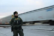 Grenzschutzbeamter Marrero-Rubio steht vor einem Zug, der parallel zur Grenze zwischen Mexiko und den USA in El Paso, Texas, entlang der Bahngleise f&auml;hrt. (National Geographic f&uuml;r Disney)
