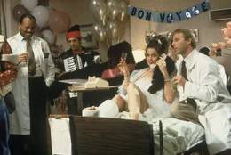 The villianess executive Katherine Parker (Sigourney Weaver) celebrates with some bedside party-goers.