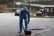 Ein Beamter wirft einen blauen Schutzanzug hinein, um die Batterie aufzubrechen. (National Geographic/Lucky 8 TV) Ein Beamter wirft einen blauen Schutzanzug hinein, um die Batterie aufzubrechen. (National Geographic/Lucky 8 TV)