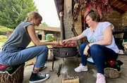 Nina Heins (li.) lernt wie Ajvar hergestellt wird.