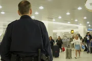 Polizist Joel Preston beobachtet ankommende Passagiere. Polizist Joel Preston beobachtet ankommende Passagiere.