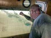 Ein Mann markiert einen Ort auf einer Landkarte