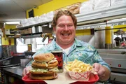 Host Casey Webb shows off the Mug-N-Bun Monster Challenge, as seen on Travel Channel's Man v. Food.