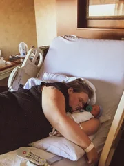 Amy rests with her newborn baby, Gage.