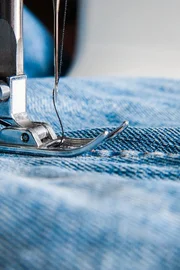 Sewing machine and blue jeans fabric. Sewing machine and blue jeans fabric.