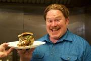 Host Casey Webb shows off the Burger Relleno at Paradise Valley Burger Co. in Phoenix, as seen on Travel Channel's Man v. Food.