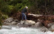 Marty Raney chopping up a log on the side of the river.