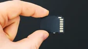 Male hand holding SD card on black background. Male hand holding SD card on black background.