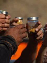 Close up - Everyone raises their jars of gold in tribute to & memory of Comrade/Husband Jesse Goins