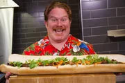 Host Casey Webb posing with Lu's Sandwich's Banh Mi Challenge in Minneapolis, Minnesota.