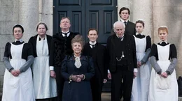 Mary (Maria Doyle Kennedy, l.), Sean Casey (Mark Williams, 3.v.l.), Mrs. Baker (Pauline Collins, 4.v.l.), Albert Nobbs (Glenn Close, m.), Patrick (James Greene, 4.v.r.), Emmy (Antonia Campbell-Hughes), 2.v.r.), Helen (Mia Wasikowska, r.)