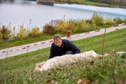 Kommissarin Janda (Jaschka L&auml;mmert) untersucht die auf der B&ouml;schung bei Donau liegende Leiche.