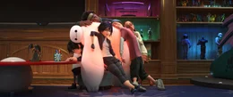 V.r.: Honey Lemon, Fred, GoGo und Wasabi chillen eine Runde auf dem luftgepolsterten Roboter Baymax und genie&szlig;en dessen W&auml;rmefunktion, w&auml;hrend Hiro verbissen einer Spur folgt.