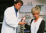Dr. Stefan Frank (Sigmar Solbach) behandelt eine Schnittverletzung bei Nicole Wandler (Iris Junik).