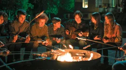 Alfons und seine Klasse h&ouml;ren Max beim Singen am Lagerfeuer zu.