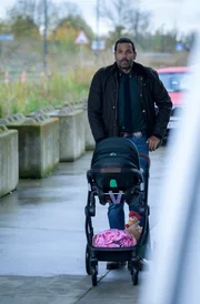 Karadec (Mehdi Nebbou) erscheint mit Kinderwagen samt L&eacute;o bei der Arbeit.