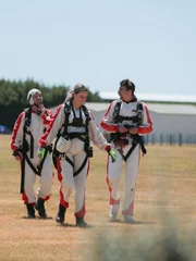 The team walking together in skydive gear.