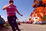 Man runs with hand in front of face away from explosion as seen on Against The Elements.