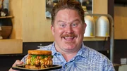 Host Casey Webb posed with the sushi burger at Jjanga Steak & Sushi in Las Vegas, NV as seen on Man v. Food, season 6.