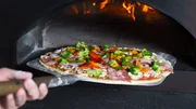 Delicious pizza going to hot stove burning by wood