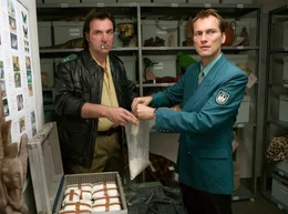 Pik beobachtet zuf&auml;llig in der Flughafentiefgarage, wie Kowatsch (Andreas Hoppe, li.) und P&ouml;hl (Herbert Sch&auml;fer) Drogen stehlen.