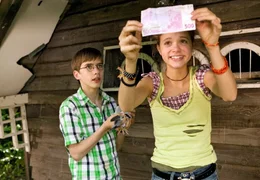 Pik (Sidonie von Krosigk) und ihr Freund Amadeus (Robin Becker) haben den ersten Geldschein von dem Fu&szlig; einer Taube abgewickelt.
