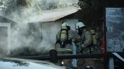 Drama: Firefighters battle fire through the smoke outside the house