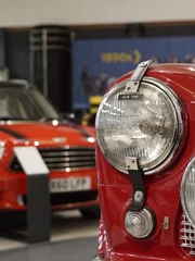 Older mini in foreground with countryman out of focus behind.