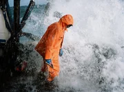 A big wave crashes over Chris Kirk as he prepares to throw the hook as seen on Deadliest Catch. A big wave crashes over Chris Kirk as he prepares to throw the hook as seen on Deadliest Catch.