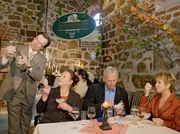 Charlotte, Otto Stein und Barbara nehmen an einer Weinverkostung teil. Nach einer Bemerkung von Otto, stuft der Reiseleiter und Weinverkoster Gero Holler Charlotte als potentielle Gro&szlig;abnehmerin f&uuml;r seinen angepriesenen Wein ein.