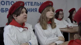 Uniformierte Schulkinder in einem Klassenzimmer.