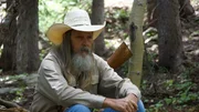 Charlie Snider takes a break on a downed log while hiking out to the Open Pit Mine with (off screen) Chad Ollinger, Eric Drummond and Josh Feldman.