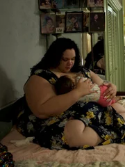 Ashley holds baby on bed