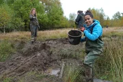 Pia baut eine Sperre, damit das Wasser nicht aus dem Moor ablaufen kann.; Pia (rechts) hilft bei der Wiedervern&auml;ssung des Schwarzen Moors.