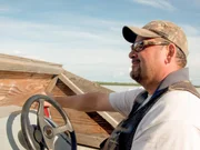 Charlie Wright driving his boat out to the Rampart to scout a spot to build his cabin.