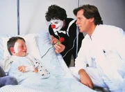 Dr. Stefan Frank (Sigmar Solbach, r.) hat Sven Lennert (Maximilian Georgi) erfolgreich behandelt. Ein Clown (Vladimir Kremen) zaubert das erste Lächeln auf Svens Gesicht. Dr. Stefan Frank (Sigmar Solbach, r.) hat Sven Lennert (Maximilian Georgi) erfolgreich behandelt. Ein Clown (Vladimir Kremen) zaubert das erste Lächeln auf Svens Gesicht.