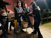 Crew member (L) films as two packers show Mariana van Zeller (back center) how they wrap a package of fentanyl to be smuggled into the U.S. (Credit: National Geographic)