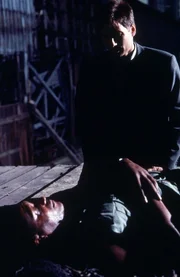 Augustus Cole (Tony Todd, liegend), der Hauptverdächtige von Mulder (David Duchovny, hinten), wird erschossen, bevor er sein großes Geheimnis preisgeben kann. Augustus Cole (Tony Todd, liegend), der Hauptverdächtige von Mulder (David Duchovny, hinten), wird erschossen, bevor er sein großes Geheimnis preisgeben kann.